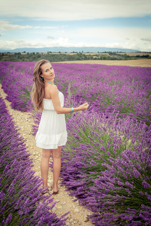 Beautiful girl in white dress on lavender fieldの写真素材