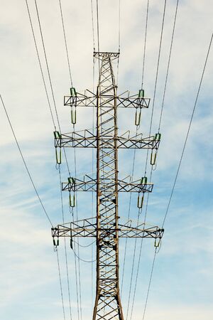 Supporting metal highvoltage power line pole against the skyの写真素材