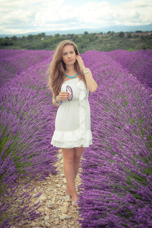Beautiful girl with a thoughtful look on a lavender fieldの写真素材