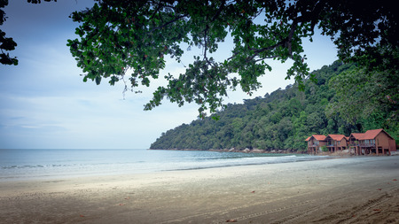Coast of a tropical island with a few bungalows on stiltsの写真素材