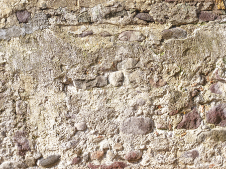 Background image of a wall of old stonework under a layer of plasterの写真素材