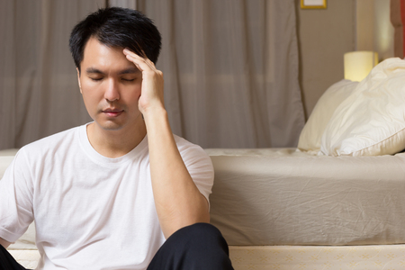 asian man worry and sleepless all night in bedroomの写真素材