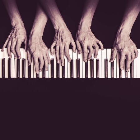 five hands playing on piano keys, black and white. music backgroundの写真素材