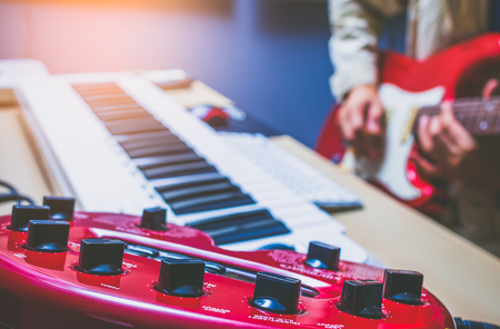 musician recording electric guitar in studio, focus on audio signal processor equipment knobsの写真素材