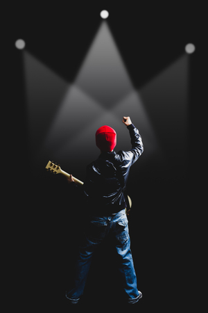 back view of asian rock guitarist playing electric guitar in concert for music contest or live show conceptの写真素材