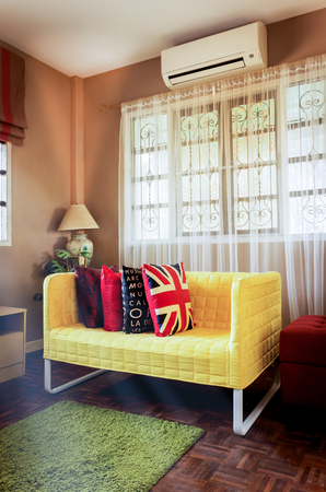 yellow fabric sofa in brown living room & morning sunlight shining from windows for asian modern contemporary interior designの写真素材