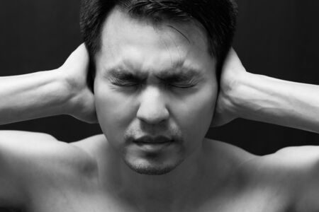 asian handsome man in black and white emotion portrait photo / feel sad ,headache and alone on dark backgroundの写真素材