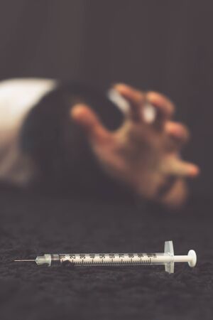 drug addict craving drugs, narcotic syringe on black floorの写真素材