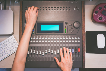 sound engineer hands working on digital sound mixer, music recording conceptの写真素材
