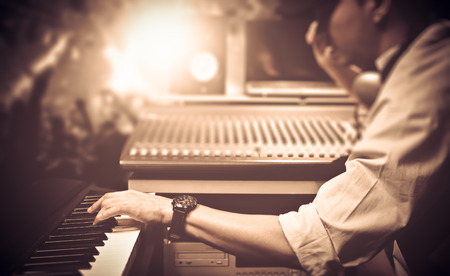 male DJ, musician playing midi keyboard synthesizer in nightclub, concert. focus on hands