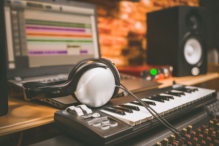 computer music, home studio equipment. headphone on midi keyboard synthesizer with laptop computer and loudspeaker monitorの写真素材