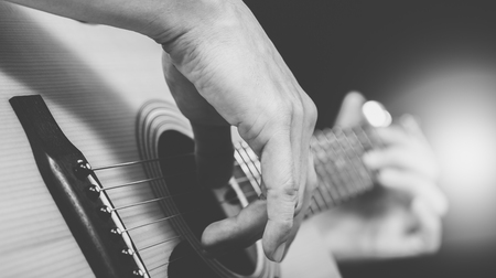 male musician playing acoustic guitar, black and whiteの写真素材