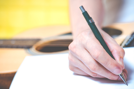 male composer hands writing a song on white paperの写真素材