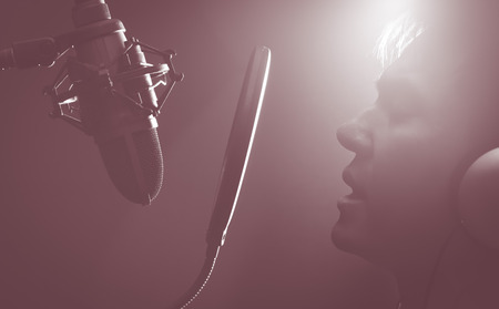 male singer singing in recording studio or DJ talking in radio broadcasting stationの写真素材