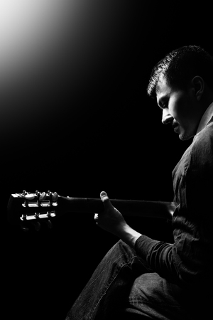 black and white portrait of asian musician playing acoustic guitar on stageの写真素材