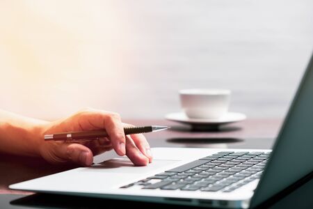 man using laptop computer working on new project idea at desk in officeの写真素材