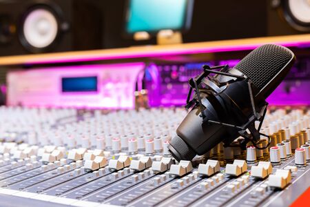 condenser microphone on audio mixing console in recording studio