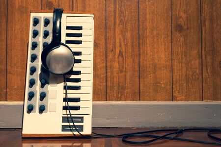 old music keyboard and headphone on floor. music background