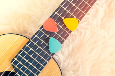 colorful pick on small acoustic guitar fretboard. music backgroundの写真素材