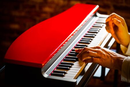 male musician playing red grand piano. music backgroundの写真素材