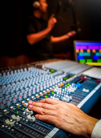 sound engineer recording singing voice on computer in recording studioの写真素材