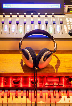 headphone, sound mixer, synthesizer on studio desk