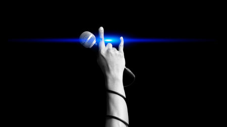 close up microphone in hand sign of singer raised his hand all the way up with blue light showing power, hope and love in live concertの写真素材