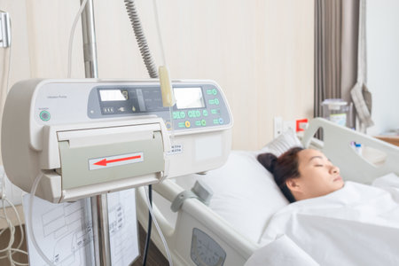 sodium chloride solution, infusion pump with female patient sleeping in bedの写真素材