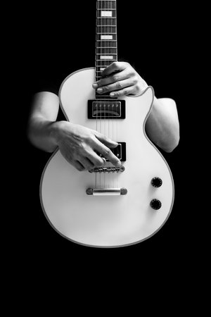 BW male musician posing on white electric guitar, isolated on black. music backgroundの写真素材