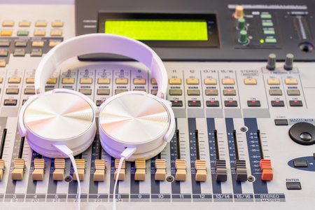 white headphone on audio mixing console. music background, recording concept