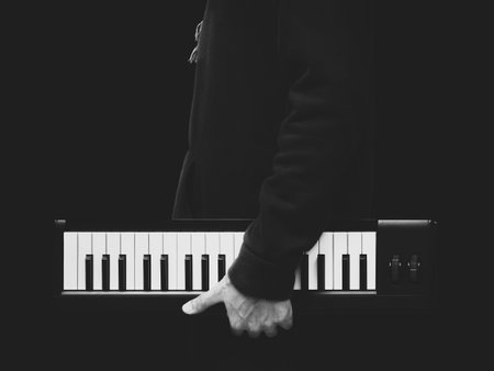 BW male musician holding music keyboard, isolated on black. music backgroundの写真素材