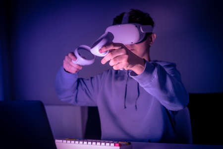 Teenager playing with virtual reality device. Cyberpunk futuristic mood, immersive experience with...