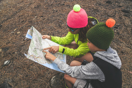 Mom and son stop during a trip in the forest in the mountains, look on the map the way to go. The...