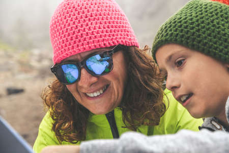 Mom and son stop during a trip in the forest in the mountains, look on the map the way to go. The...