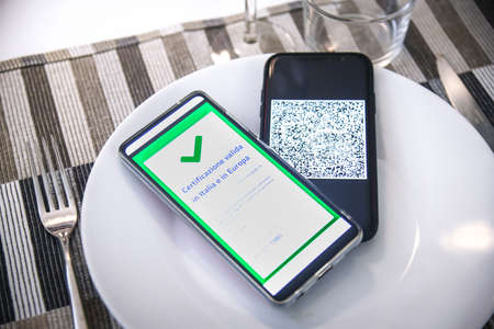 Checking the green pass on smartphone. Required for indoor tables in bar, restaurants and company...