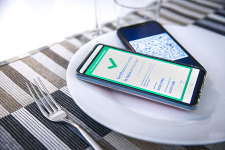Checking the green pass on smartphone. Required for indoor tables in bar, restaurants and company canteens. Valid certification. Milan, Italy - September 2021のeditorial素材