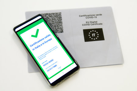 Checking the green pass on smartphone. Required for indoor tables in bar and restaurants, events and to access workplaces and company canteens. Valid certification. Milan, Italy - September 2021のeditorial素材