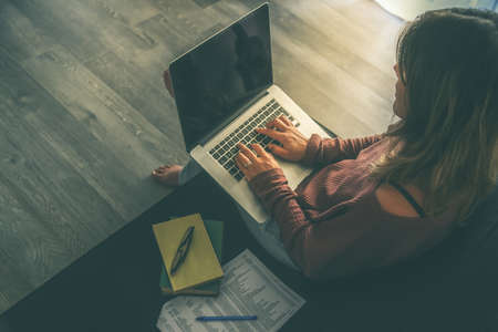 Young woman working on laptop at home. Female hands typing on pc keyboard. Teenager making an...