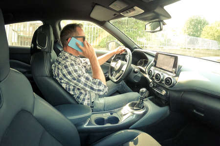 Man drive a car and use infotainment. Driver male reading messages and make phone call while...