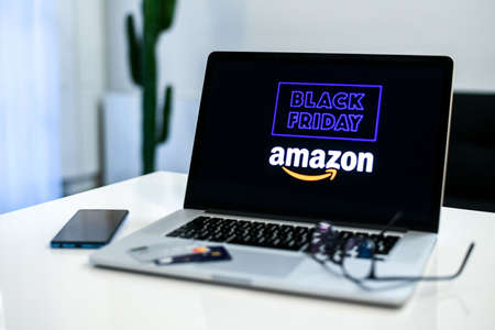 Purchasing Christmas gift in the Amazon online shop the black friday. Logo on the laptop monitor....