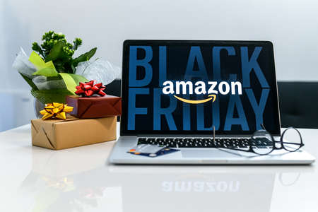 Purchasing Christmas gift in the Amazon online shop the black friday. Logo on the laptop monitor....