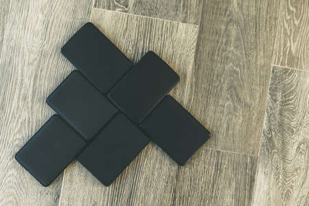 Many portable hard drives on the wooden floor. Mosaic of usb storage devices. External computer equipment. Cloud technology, online disk, remote backup, security copy and archiving Internet concept.の写真素材