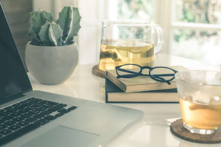 Morning time at home healthy breakfast laptop and cup of lemon tea on table. Natural meal at work in remote office, health hot drinks with computer freelance desktop workspace. Home working concept.の写真素材