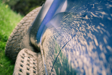 Close-up of a muddy wheel. Big tire of an off-road vehicle with mud. Splatters of mud on the side of the pick-up. Adventure, outdoor, 4x4, extreme, travel, mountain excursion concept. Vehicle off roadの写真素材