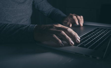 Hands typing on laptop keyboard. Man working on computer. Dark moods. Technology, business concept