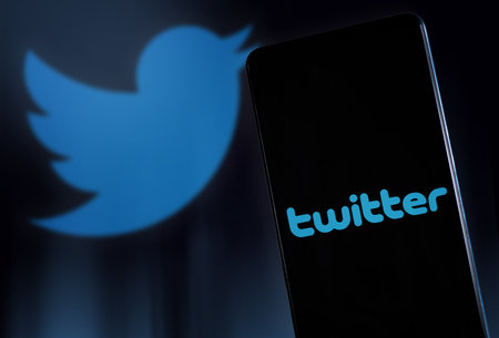 Twitter logo on smartphone screen and background. Communication concept. Milan Italy January 2023