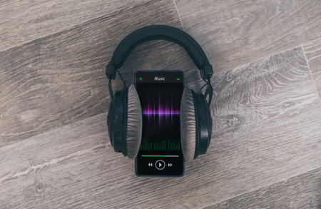 Smartphone playing music with headphones. Wooden background. Radio broadcast audio streaming concept