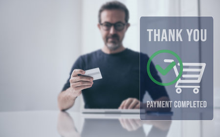 Man behind computer keyboard, purchase and pay online. Credit card in hand. Secure payment completedの写真素材