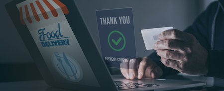 Man behind computer purchase food online. Credit card in hand. Home delivery, catering concept.の写真素材