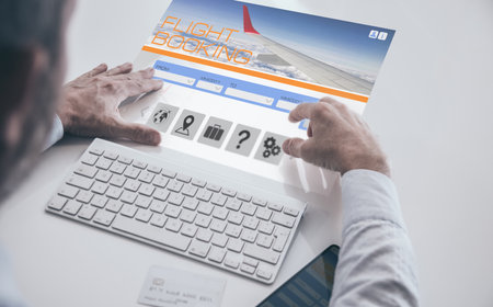 Businessman booking flight ticket on virtual desktop screen. Plan travel and book business tripsの写真素材